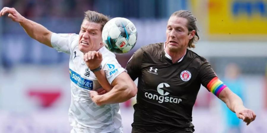 Der Sandhausener Kevin Behrens (l) im Zweikampf mit Daniel Buballa vom FC St. Pauli. Foto: Uwe Anspach/dpa