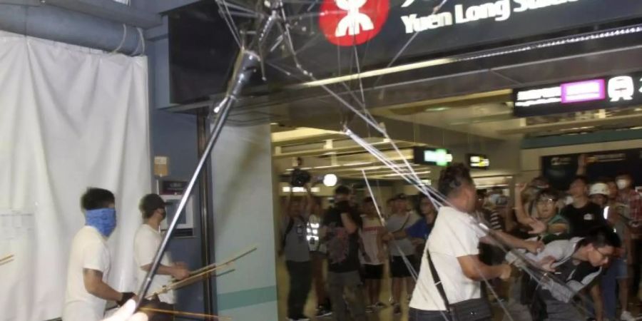 Gegen diese Übergriffe vom vergangenen Wochenende will die Protestbewegung in Hongkong demonstrieren: Männer in weissen Hemden, bewaffnet mit Metallstangen und Holzknüppeln, greifen regierungskritische Demonstranten an. Foto: Apple Daily/AP