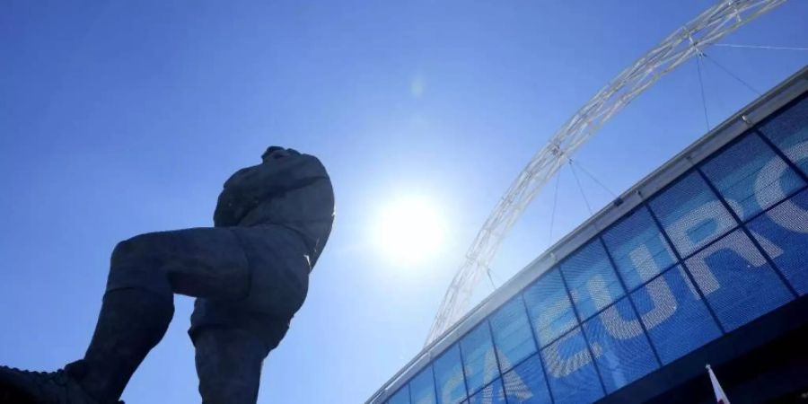 Die Statue von Englands Fussballlegende Bobby Moore steht vor dem UEFA-Euro-Schild am Eingang des Wembley-Stadions. Foto: Frank Augstein/AP/dpa