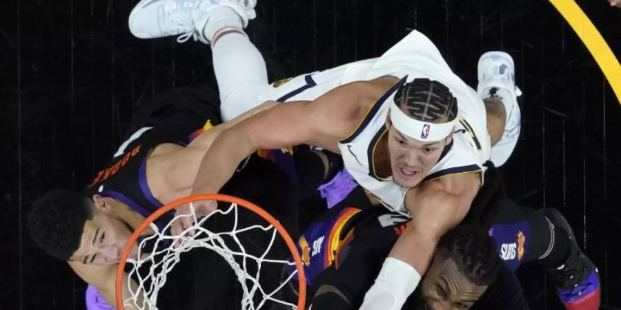 Denvers Forward Aaron Gordon setzt sich gegen Devin Booker (l) und Jae Crowder (r) von den Phoenix Suns durch. Foto: Matt York/AP/dpa