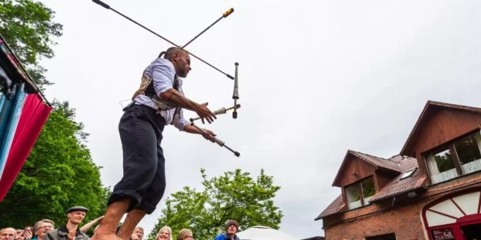 Ein Strassenkünstler vom «Chaos Variete» jongliert bei der Kulturellen Landpartie im Wendland auf einem Hof mit Fackeln. Foto: Philipp Schulze/dpa Ein Strassenkünstler vom «Chaos Variete» jongliert bei der Kulturellen Landpartie im Wendland auf einem Hof mit Fackeln. Foto: Philipp Schulze/dpa