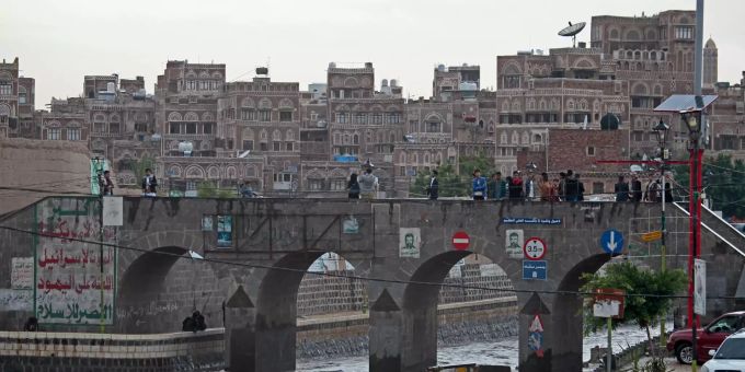 Passanten gehen in Jemen über eine Brücke. Überschwemmungen im Jemen