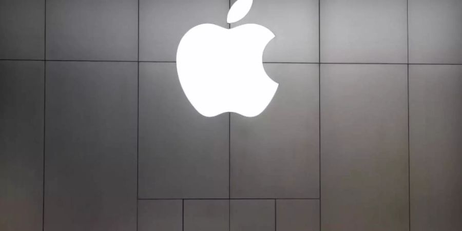 Zwei junge Frauen mit Mundschutz stehen vor einem Apple-Store in Peking. Foto: Mark Schiefelbein/AP/dpa