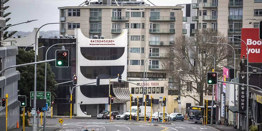 Menschen überqueren eine fast leere Strasse im zentralen Geschäftsviertel von Auckland. Die Regierung von Ministerpräsidentin Jacinda Ardern gab am Montag bekannt, dass die neuseeländische Metropole eine weitere Woche im strikten Corona-Lockdown bleibt. Foto: Michael Craig/New Zealand Herald/dpa