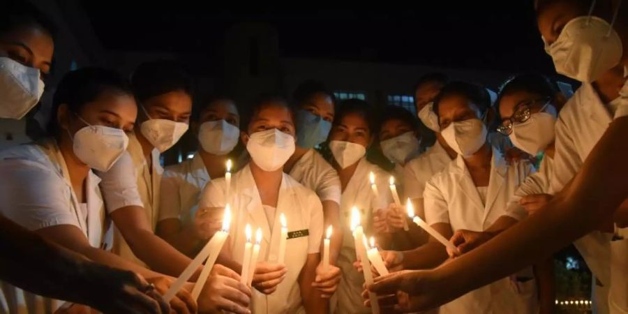 Krankenschwestern erinnern mit Kerzen an die verstorbenen Ärzte, die ihr Leben durch Corona verloren haben. Foto: Dasarath Deka/ZUMA Wire/dpa