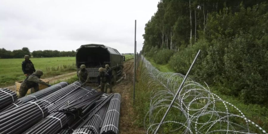 Polnische Soldaten bauen Grenzzaun