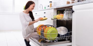 Lächelnde Frau am Geschirrspüler