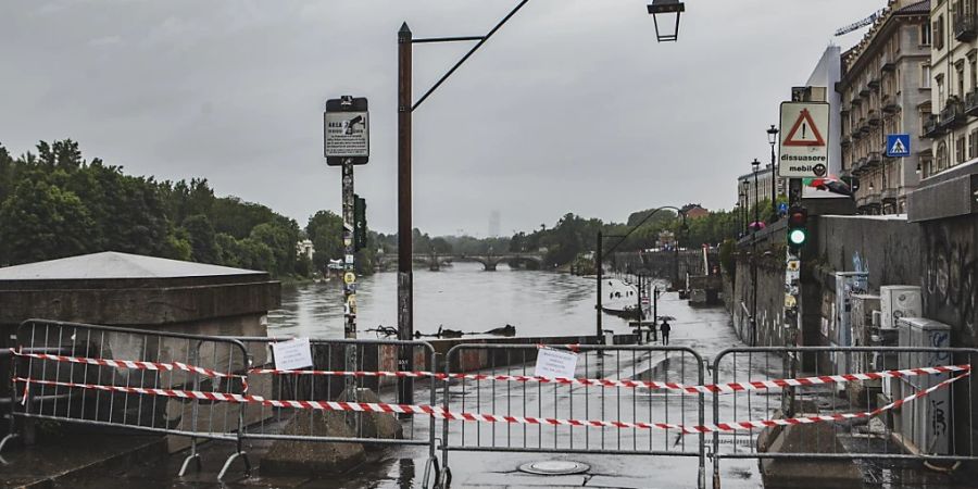 Barrieren wurden im Murazzi-Gebiet aufgestellt, die den Zugang zum Flussgebiet im Stadtzentrum einschränken. Das Hochwasser und die vielen Erdrutsche machen den betroffenen Gebieten weiter zu schaffen. Foto: Andrea Alfano/LaPresse/AP/dpa