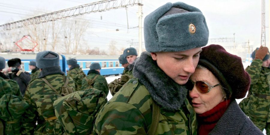 Ein junger Rekrut, der zum Militärdienst einberufen worden ist, umarmt vor der Abreise in die westsibirische Stadt Kemerowo seine Mutter.