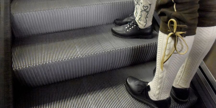 Trachtler stehen auf den Stufen einer Rolltreppe in München, nachdem sie das Oktoberfest verlassen haben.