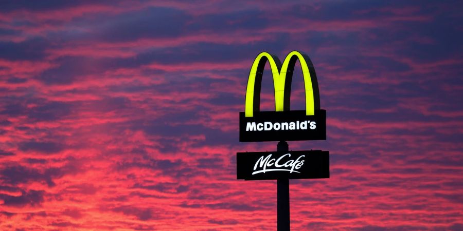 Der Abendhimmel leuchtet hinter McDonald's. Die Fastfood-Kette bleibt grösster Arbeitgeber unter den US-Firmen in Deutschland.