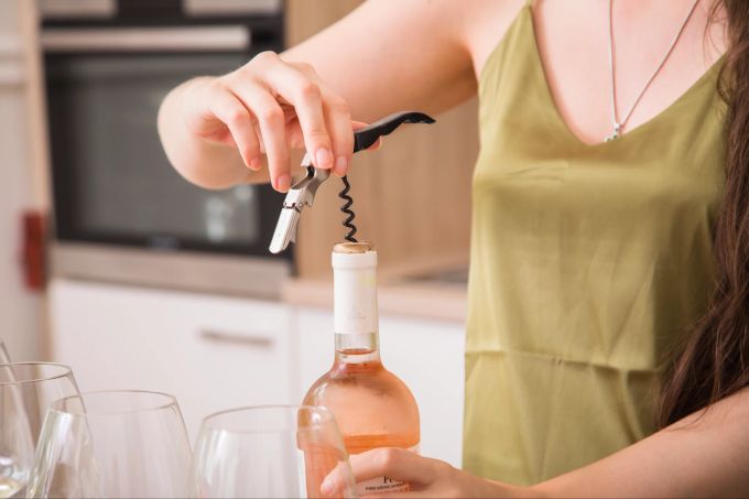 Alkoholfreie Weine gibt es in Rot, Weiss und Rosé. Sie dürfen bis zu 0,5 Volumenprozent Alkohol enthalten. Frau öffnet Wein