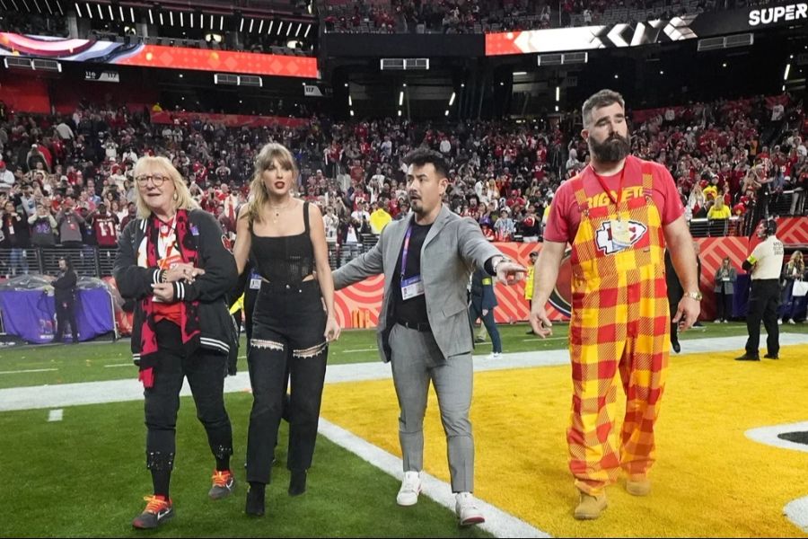 Donna Kelce (links), Taylor Swift (Zweite v. links) und Bruder von Travis Kelce, Jason Kelce (rechts), auf dem Spielfeld nach dem Sieg der Kansas City Chiefs.