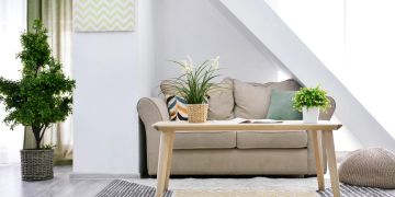 Kleines Wohnzimmer mit Couch, Tisch und Pflanzen