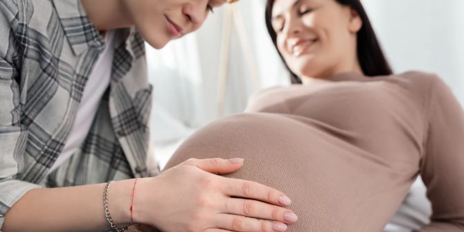 Frau fässt Schwangeren an den Bauch