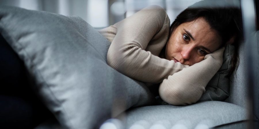 Depressive Frau im Bett