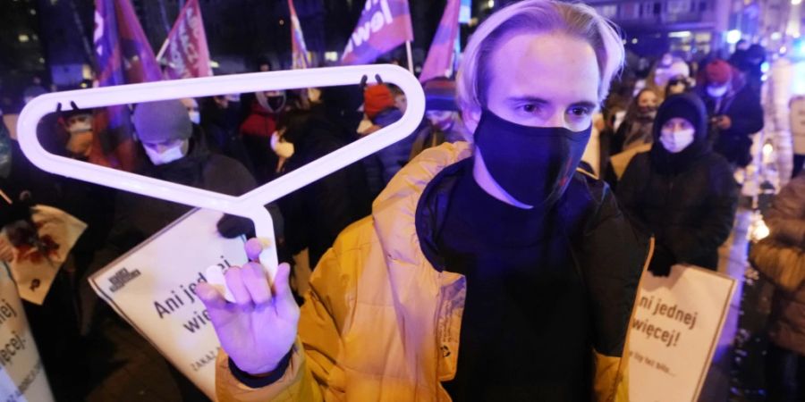 ARCHIV - Ein Demonstrant hält einen Kleiderbügel, ein Symbol für gefährliche illegale Schwangerschaftsabbrüche, während einer Demonstration vor dem polnischen Parlament. Das mitregierende Linksbündnis Lewica hat für eine Entkriminalisierung von Abtreibungen bis zur 12. Schwangerschaftswoche geworben. Foto: Czarek Sokolowski/AP/dpa