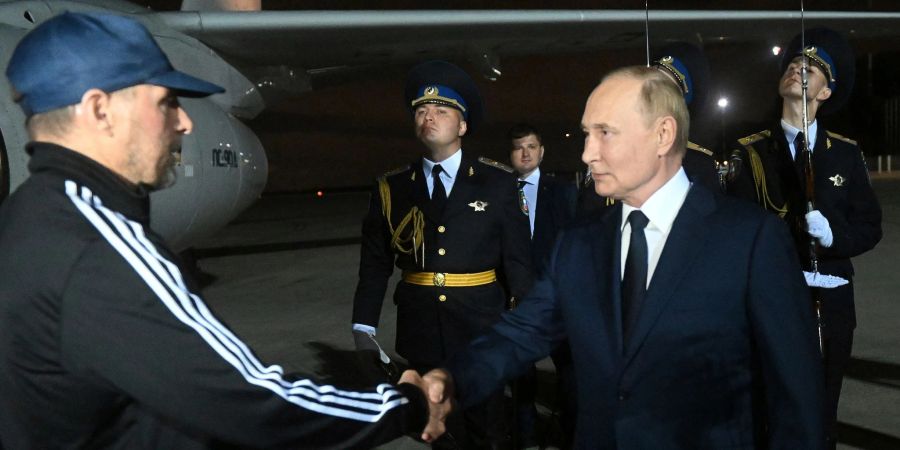 Der verurteilte Mörder Wadim Krassikow (l) wurde am Flughafen von dem russischen Präsidenten Wladimir Putin (r) empfangen.