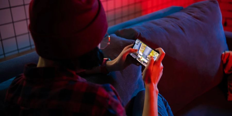 Frau Couch Smartphone Gaming dunkel Neonlicht