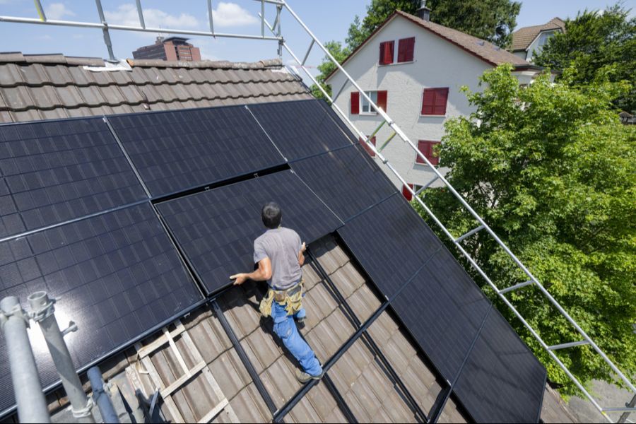 Der Installateur Beat Wolfisberg von der Firma BeNetz bei der Installation einer Photovoltaikanlage auf dem Dach eines Einfamilienhauses in Luzern, am 25. Juni 2024.