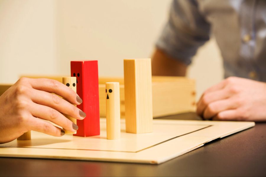 Stockfotografie Familienaufstellungsausschuss mit Holzfiguren.