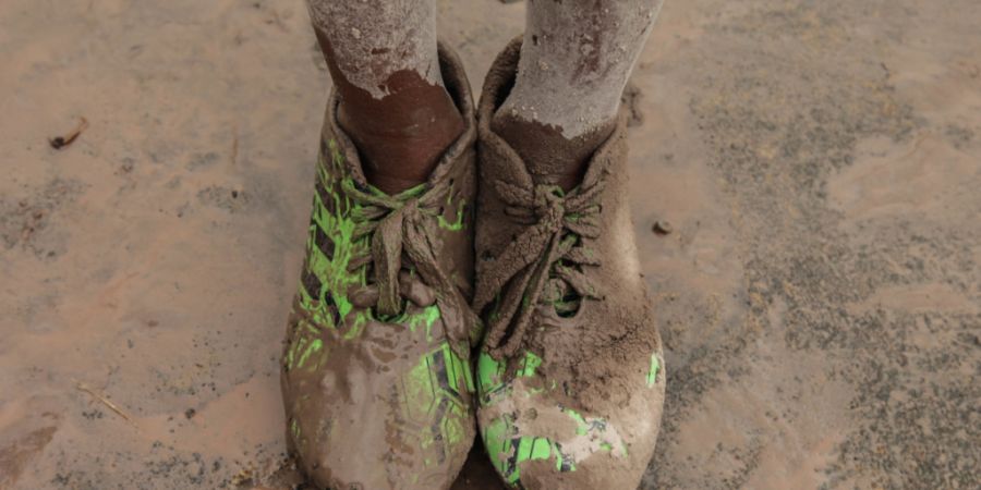 ARCHIV - Mit Vulkanasche verschmutzte Schuhe eines Jungen. Foto: Albert Ivan Damanik/ZUMA Wire/dpa/Archivbild