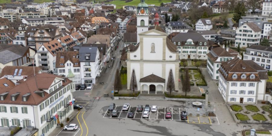 Der Seeplatz mit dem Parkplatz und der Katholischen Kirche St. Peter und Paul im Dorfzentrum von Küssnacht SZ.