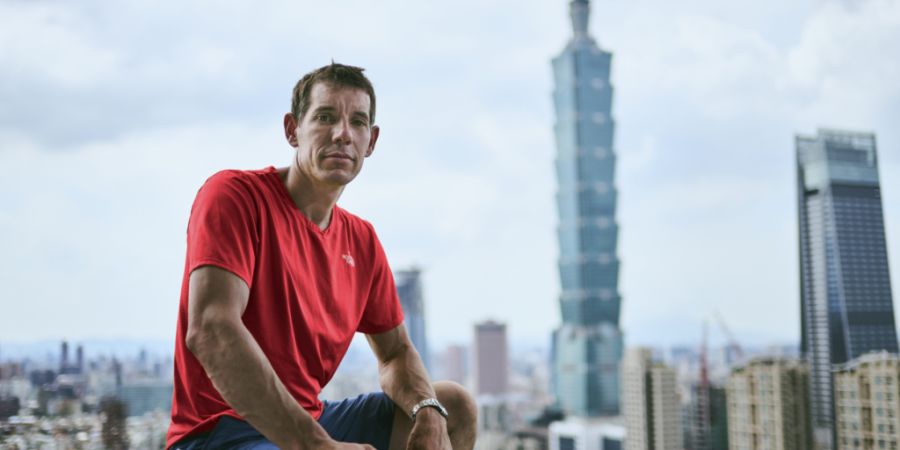 HANDOUT - Alex Honnold sitzt in Taipei auf einem Geländer vor Hochhäusern. In der Nacht auf Samstag (24.01.2026) um 02.00 Uhr (MEZ) will Freeclimber Alex Honnold einen der höchsten W...