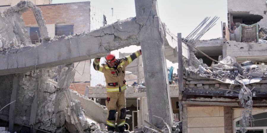 dpatopbilder - Ein Ersthelfer inspiziert die beschädigte Struktur eines Wohnhauses in Teheran. Foto: Vahid Salemi/AP/dpa