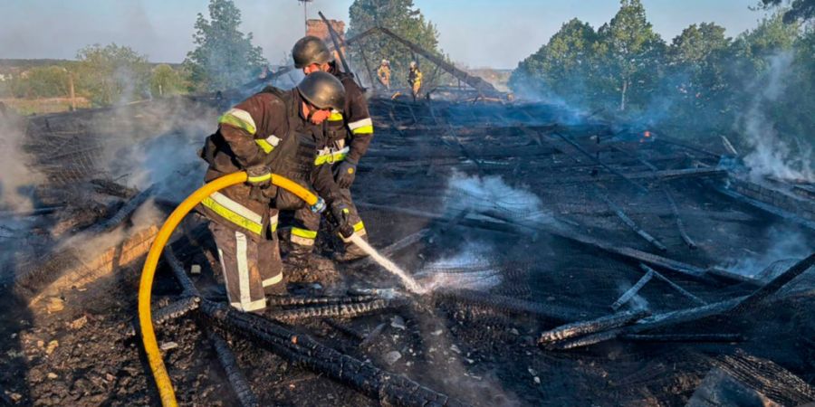 HANDOUT - Auf diesem vom ukrainischen Katastrophenschutz via AP zur Verfügung gestellten Foto arbeiten Rettungskräfte daran, einen Brand nach einem russischen Drohnenangriff in der Re...