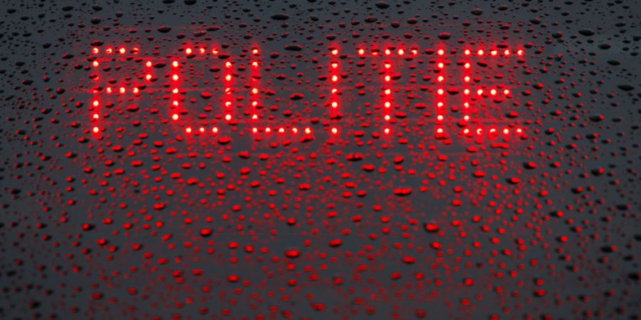 ARCHIV - Das niederländische Wort «Politie» («Polizei») wird in der Heckscheibe von einem Einsatzfahrzeug angezeigt. Foto: Friso Gentsch/dpa