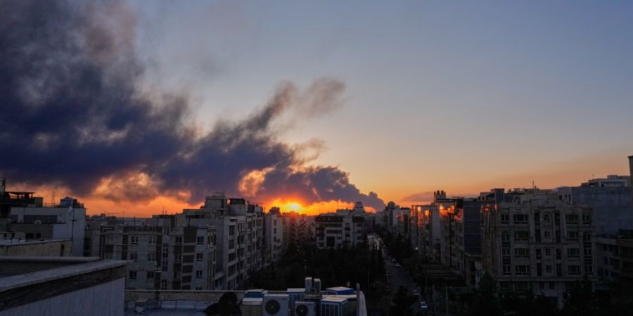 ARCHIV - Die Sonne geht hinter einer Rauchwolke unter, die nach einem amerikanisch-israelischen Militärschlag aufsteigt. Foto: Vahid Salemi/AP/dpa