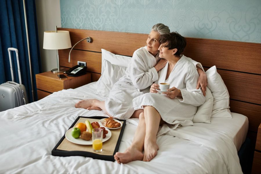 lesbische frauen im bademantel, beim frühstück im hotel