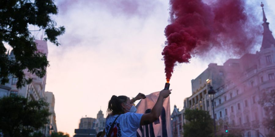 Eine Frau hält eine Leuchtfackel in der Hand während eines Protests im Anschluss an die Zwangsräumung einer 87-jährigen Frau am vergangenen Mittwoch. Foto: Manu Fernandez/AP/dpa