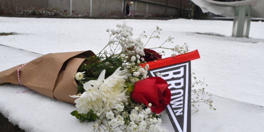 Ein Blumenstrauß liegt auf dem Schnee auf dem Campus der Brown University. Foto: Steven Senne/FR172182 AP/AP/dpa