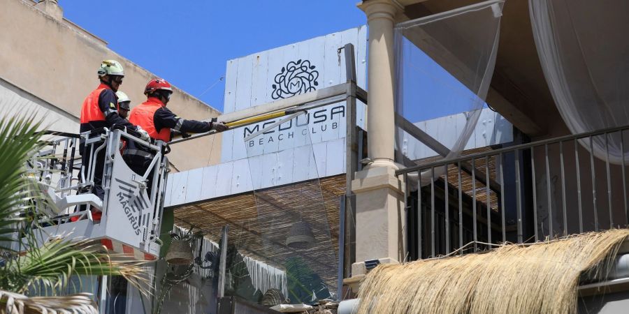 Feuerwehrleute arbeiten nach dem Einsturz am Gebäude des Medusa Beach Club auf Mallorca.
