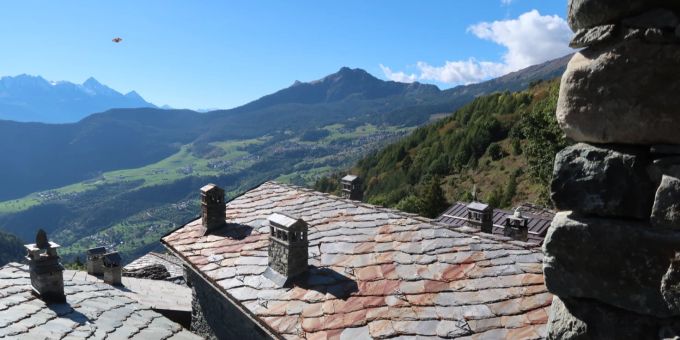 Weiter Ausblick vom Bergdorf. Schieferdach Ausblick Berge grün