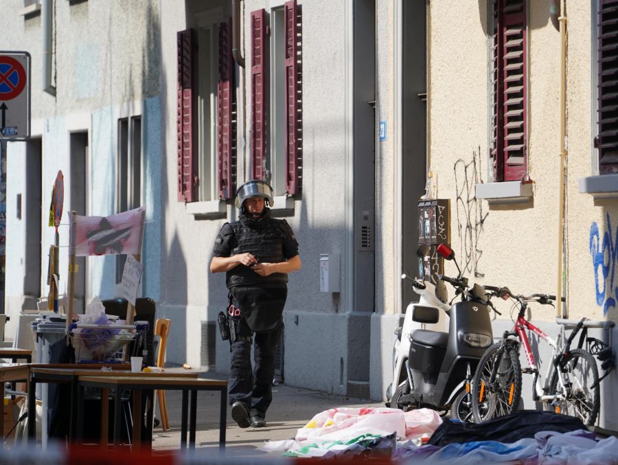 Ein Polizist vor dem besetzten Gebäude in Schutzmontur.