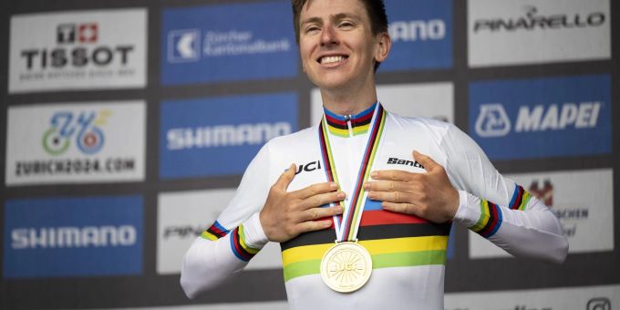 Tadej Pogacar zeigt stolz das Regenbogen-Trikot.