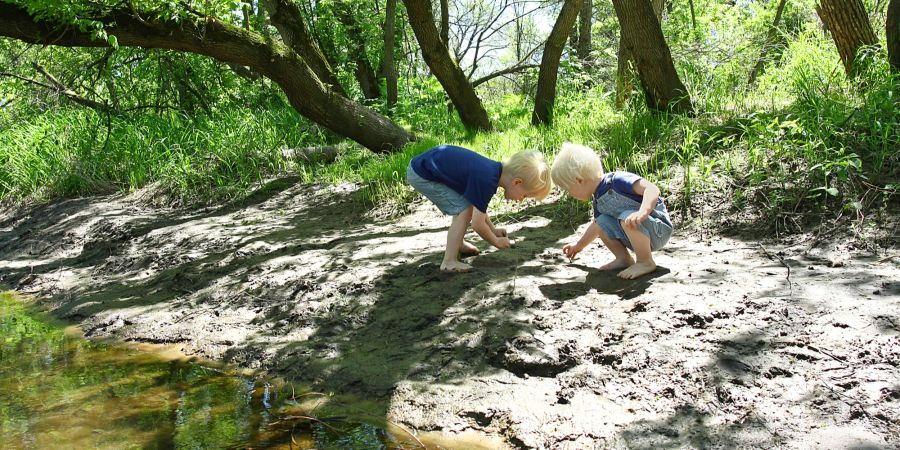 Kinder spielen am Bach