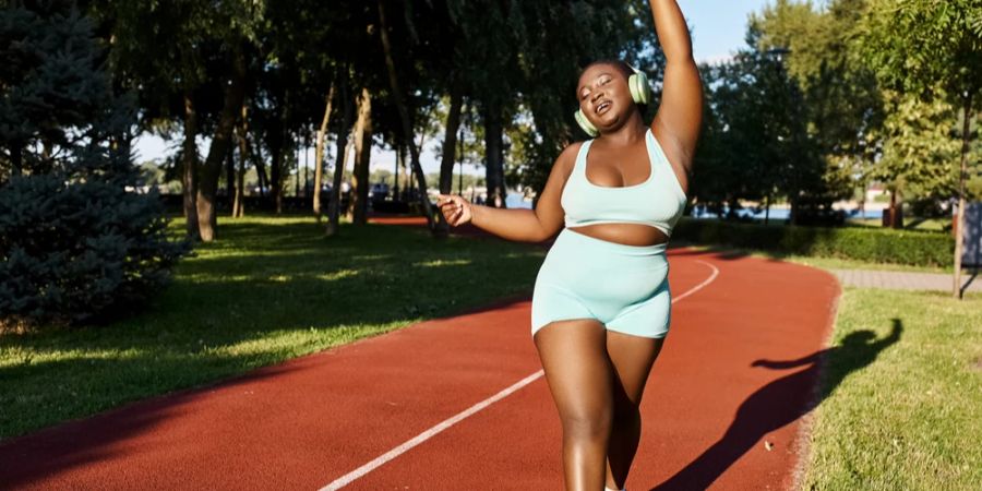 Frau selbstbewusst Sportkleidung Sommer fröhlich Musik auf den Ohren