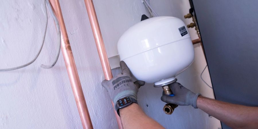 Kann sich lohnen: Der Einbau einer geförderten Heizung - hier wird der Ausgleichsbehälter montiert.