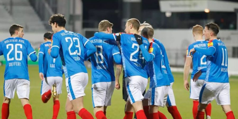 Die Kieler feiern das 1:0 über die Würzburger Kickers. Foto: Frank Molter/dpa