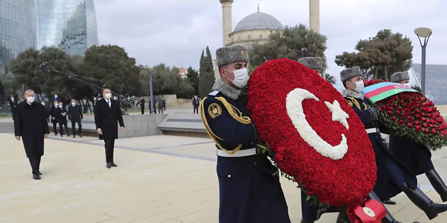 Recep Tayyip Erdogan (hinten, l), Staatspräsident der Türkei, und Ilham Alijew (hinten, r), Präsident von Aserbaidschan, nehmen an einer Kranzniederlegung teil. Zuvor waren sie bei einer Militärparade, mit der Aserbaidschan seinen «Sieg» im Krieg um die Südkaukasus-Region Berg-Karabach feierte. Foto: -/Turkish Presidency/AP/dpa