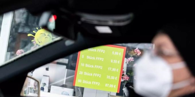 Eine Person trägt eine Maske im Auto. maske auto