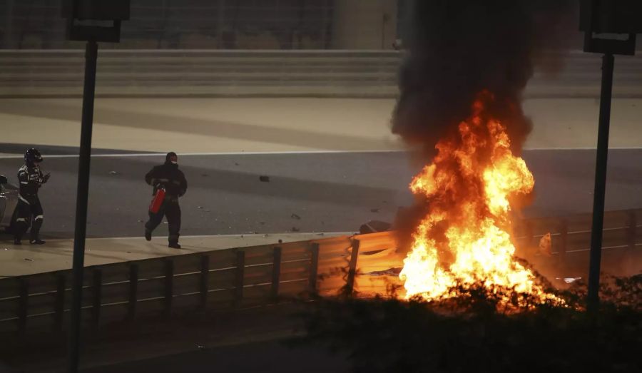 Flammen schlagen aus dem Wrack von Romain Grosjeans Haas VF20. Links eilen Dr. Ian Roberts und ein Streckenposten zu Hilfe.