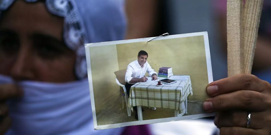 ARCHIV - Eine Unterstützerin der pro-kurdischen Partei HDP hält ein Bild von Selahattin Demirtas, dem früheren Co-Vorsitzenden der HDP, bei einer Kundgebung in der Hand. Foto: Emrah Gurel/AP/dpa