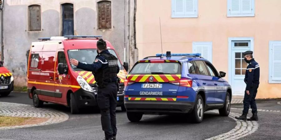 Ein Polizist regelt den Verkehr für vorbeifahrende Einsatzfahrzeuge der Feuerwehr. In einem französischen Dorf hat ein Mann laut Agenturberichten drei Polizisten erschossen. Foto: Olivier Chassignole/AFP/dpa