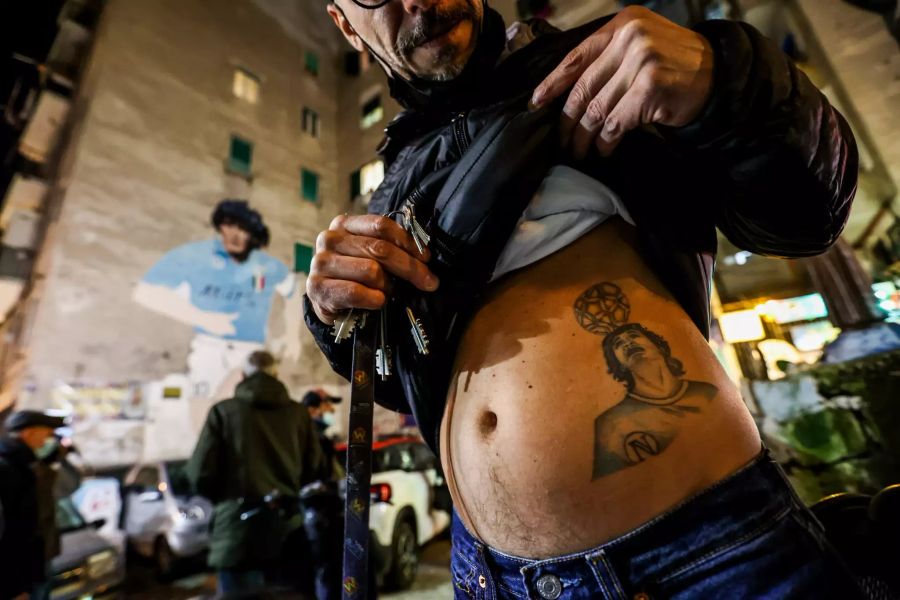 Ein Mann in Neapel zeigt sein Tattoo von Diego Maradona.