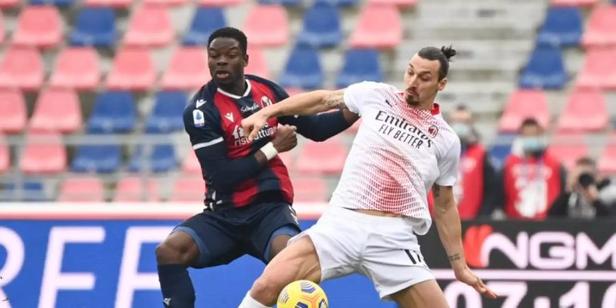 Zlatan Ibrahimovic (r) vom AC Mailand kämpft mit Adama Soumaoro vom FC Bologna um den Ball. Foto: Massimo Paolone/LaPresse via ZUMA Press/dpa